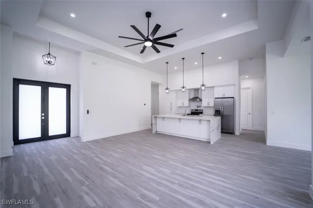 a view of a room with wooden floor and a ceiling fan