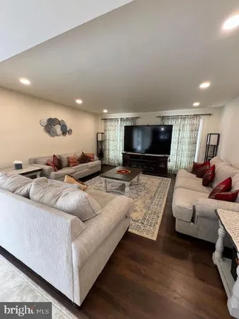 a living room with furniture flat screen tv and a couch