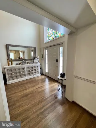 a view of a living room with hardwood floor and a ceiling fan