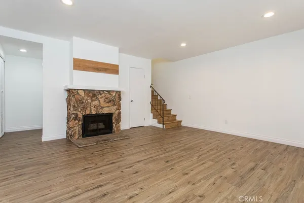 a view of empty room with wooden floor and fireplace