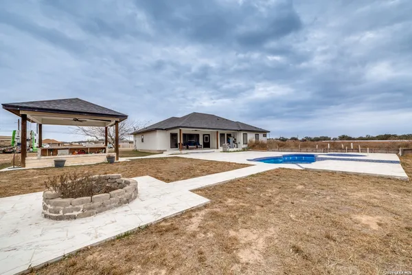 a view of a house with swimming pool and sitting area
