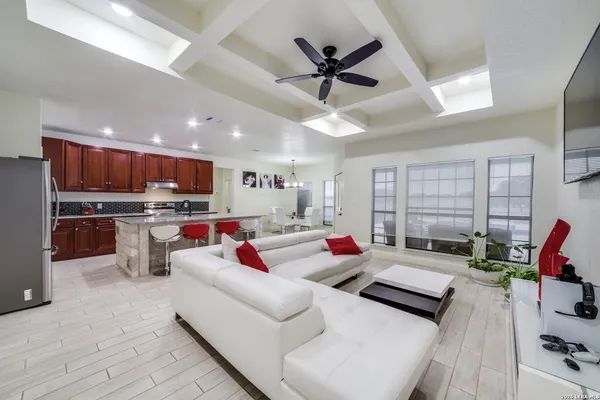 a living room with furniture kitchen view and a large window