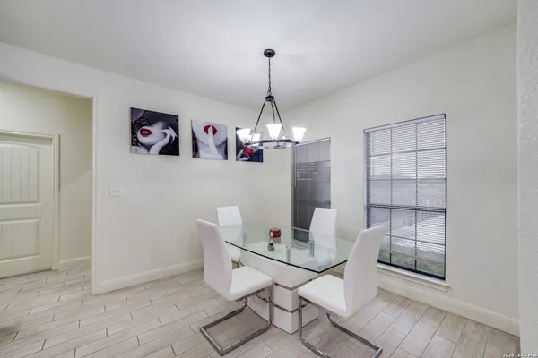 a dining room with wooden floor and a chandelier