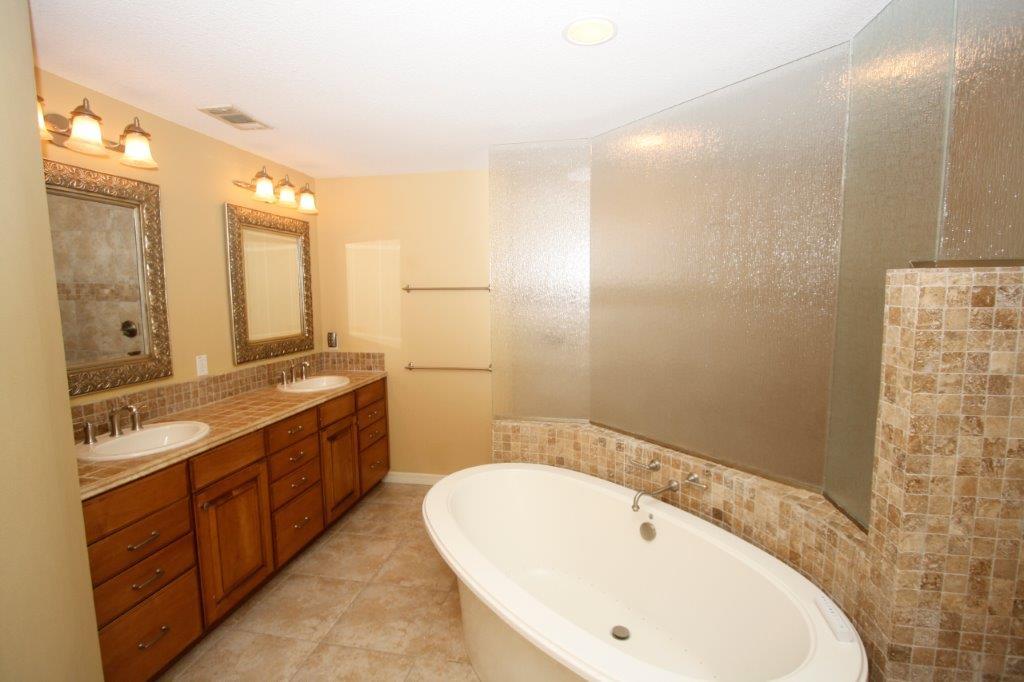 129 Walton Way Miramar Beach, FL 32550 - Photo 12 of 29 a bathroom with a double vanity sink and mirror with shower
