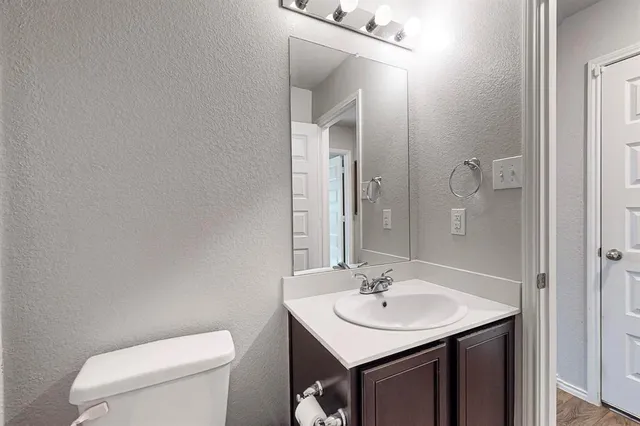a bathroom with a sink a toilet and mirror