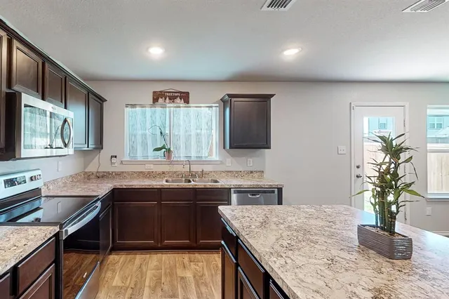 a kitchen with stainless steel appliances granite countertop sink stove and cabinets