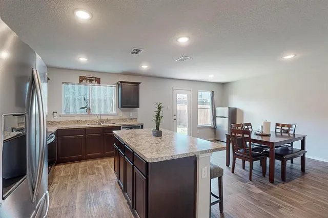 a kitchen with granite countertop kitchen island wooden cabinets and stainless steel appliances