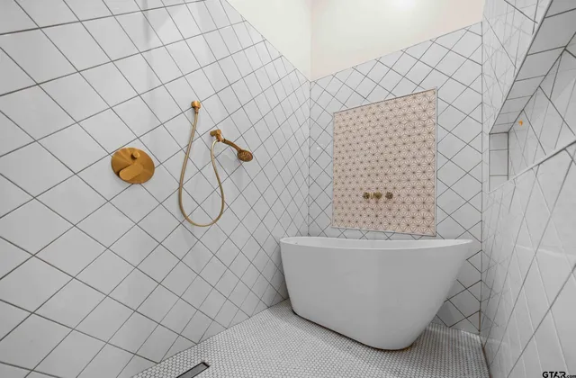 a white bath tub sitting next to a white wall