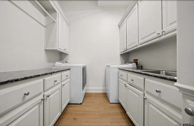 a kitchen with granite countertop white cabinets and sink