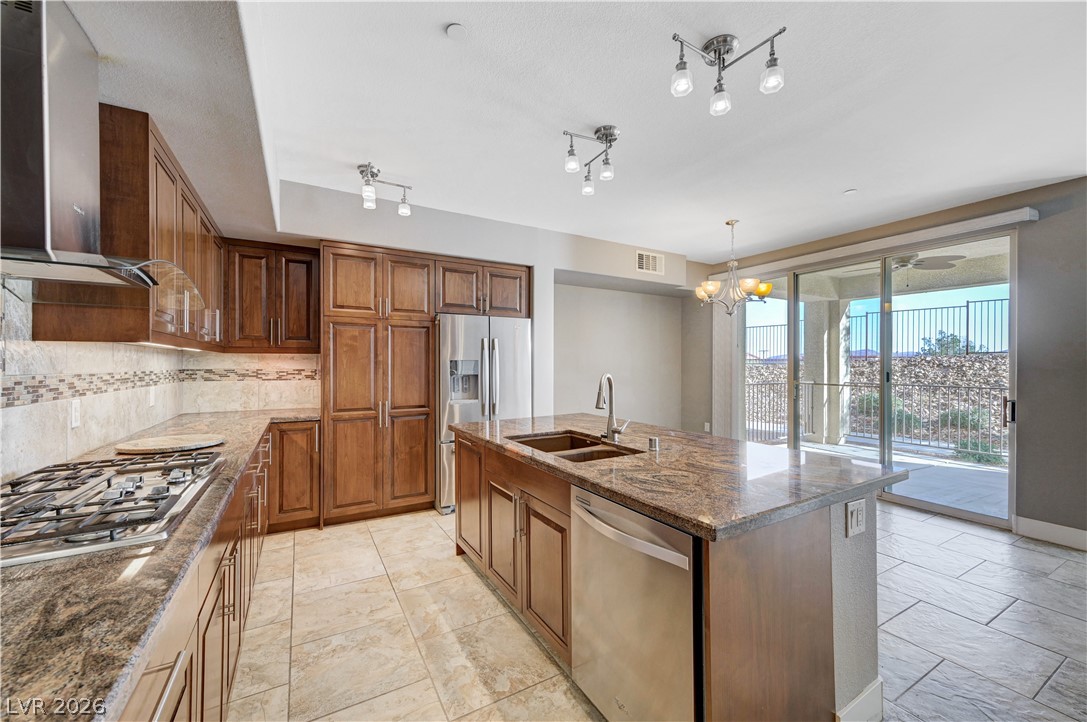 2555 Hampton Road, Unit 6108 Henderson, NV 89052 - Photo 11 of 63 Kitchen featuring stainless steel appliances, dark stone countertops, an island with sink, wood finish cabinetry, and tasteful backsplash