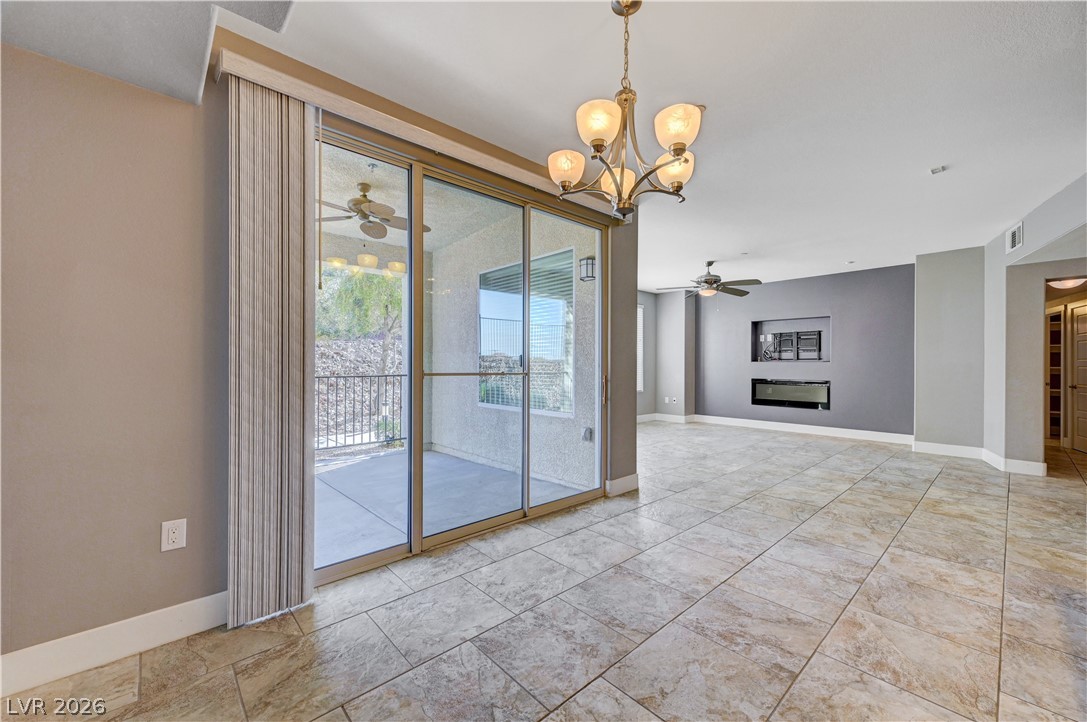 2555 Hampton Road, Unit 6108 Henderson, NV 89052 - Photo 14 of 63 Spare room with ceiling fan, hanging lights, and a glass covered fireplace