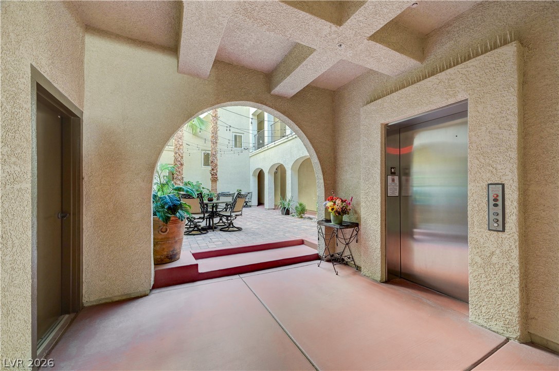 2555 Hampton Road, Unit 6108 Henderson, NV 89052 - Photo 30 of 63 Corridor featuring arched walkways, coffered ceiling, a textured wall, concrete floors, and elevator