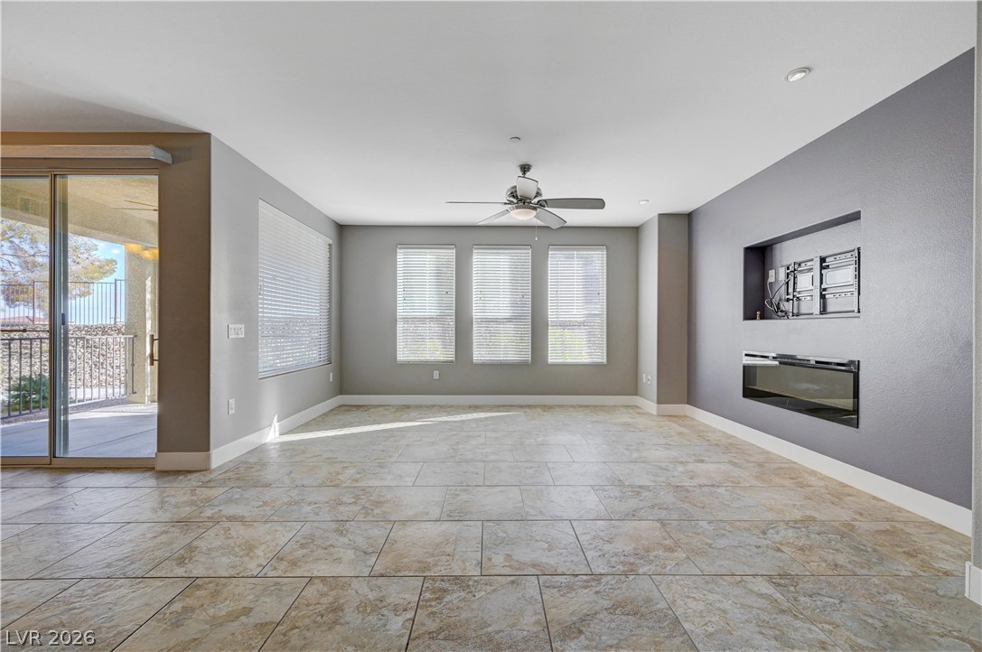2555 Hampton Road, Unit 6108 Henderson, NV 89052 - Photo 5 of 63 Unfurnished living room featuring ceiling fan and a glass covered fireplace