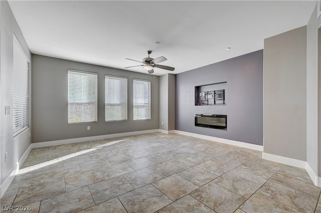 2555 Hampton Road, Unit 6108 Henderson, NV 89052 - Photo 7 of 63 Unfurnished living room with a ceiling fan and a glass covered fireplace