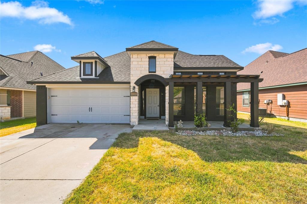 10409 Condor Loop Waco, TX 76708 - Photo 1 of 26 Contemporary two-story residence featuring a brick and stone exterior with a prominent rounded turret tower and pitched roofline