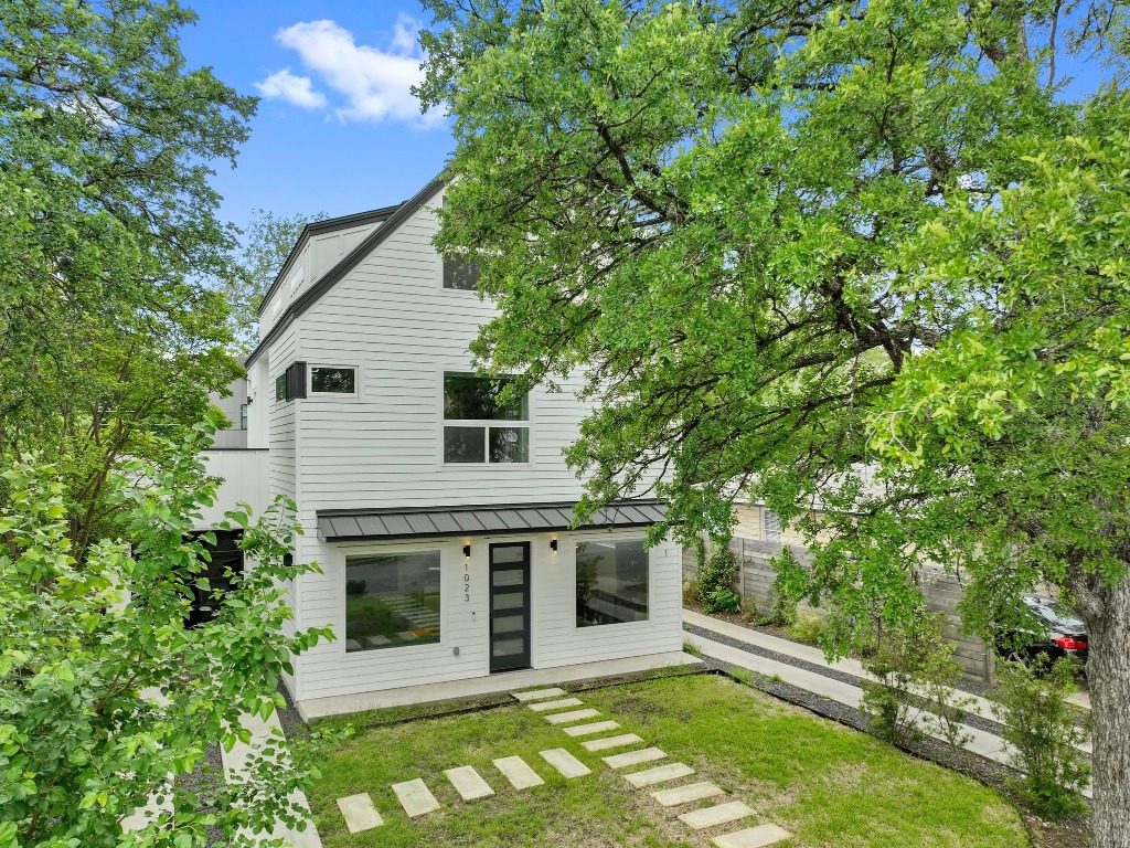 a view of house with backyard and a garden