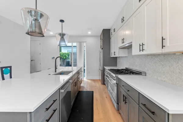 a kitchen with stainless steel appliances a sink a stove a refrigerator and cabinets