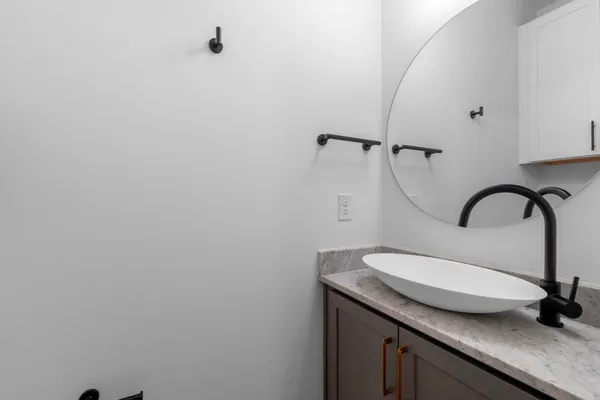 a bathroom with a granite countertop sink a toilet and a shower
