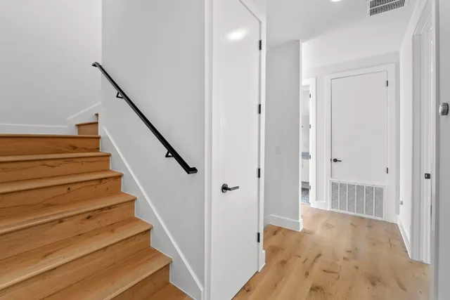 a view of a hallway with wooden floor and entryway