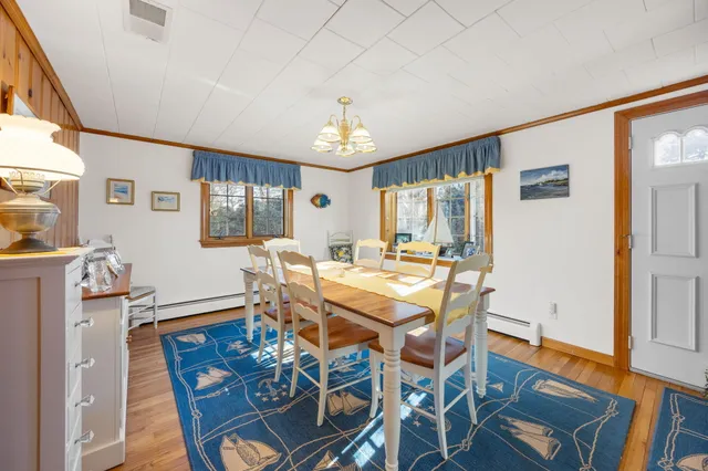 a view of a dining room with furniture a chandelier and wooden floor