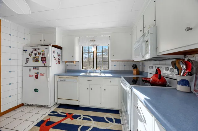 a kitchen with stainless steel appliances granite countertop a sink stove and white cabinets