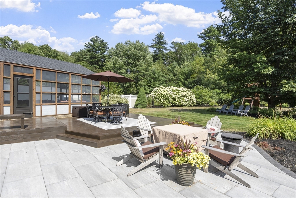 51 Still River Road Bolton, MA 01740 - Photo 36 of 41 a view of a patio with couches chairs and a table and chairs with wooden floor and fence