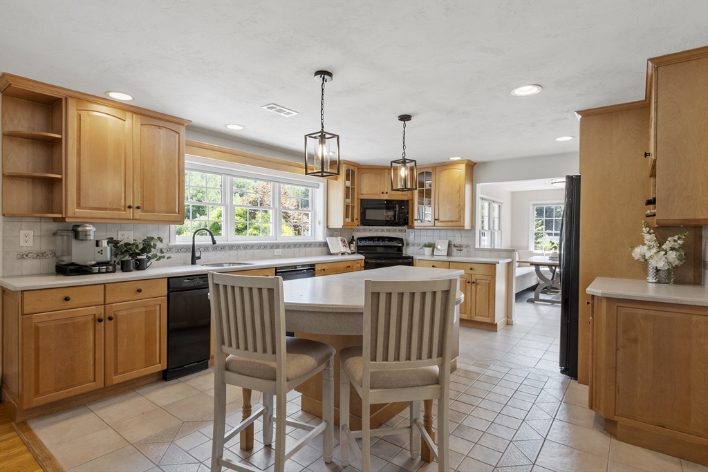 51 Still River Road Bolton, MA 01740 - Photo 4 of 41 a kitchen with kitchen island granite countertop a table chairs microwave and cabinets