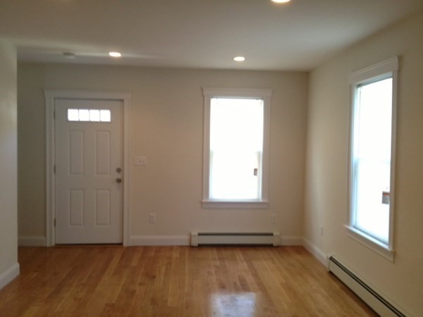 200 Brooks Street, Unit 1 Boston, MA 02128 - Photo 6 of 10 an empty room with wooden floor and windows