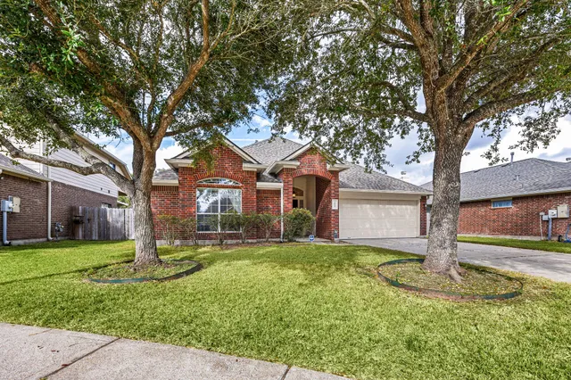 a front view of a house with a yard and trees