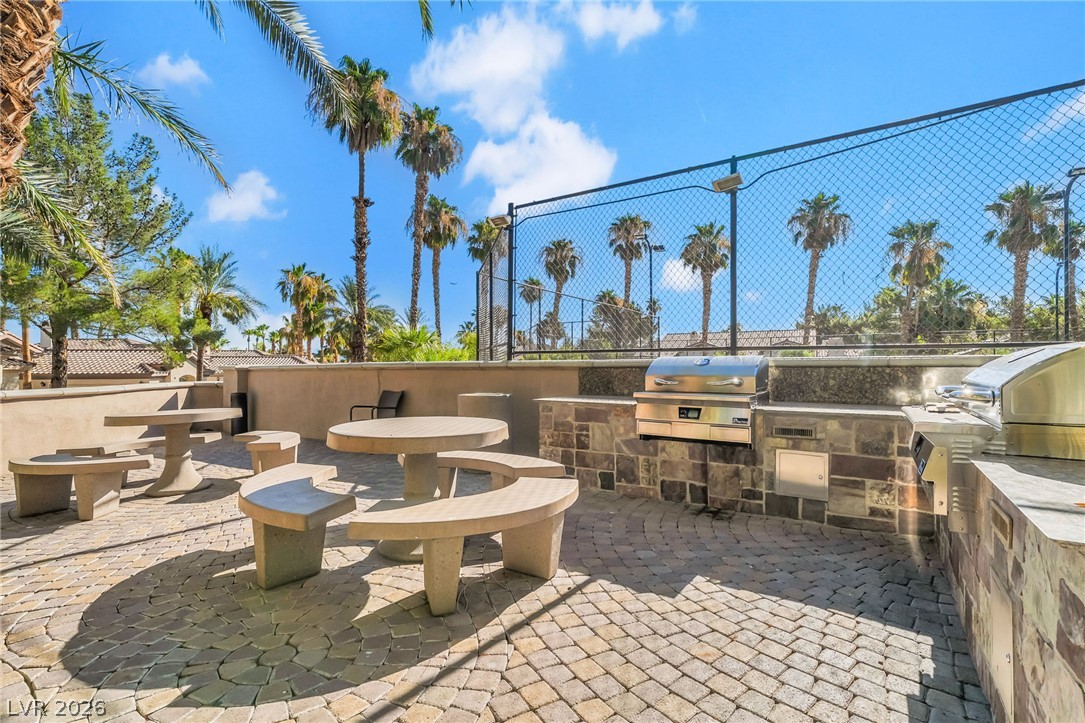 2050 West Warm Springs Road, Unit 2411 Henderson, NV 89014 - Photo 36 of 37 Enjoy outdoor gatherings with a fully-equipped barbecue area featuring ample seating and lush palm trees.