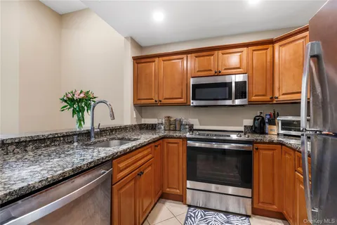 a kitchen with stainless steel appliances granite countertop a sink stove and microwave