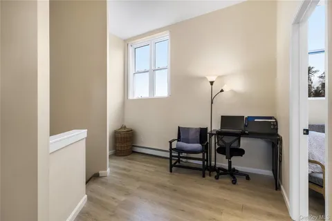 a view of a workspace with furniture and a window