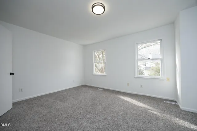 an empty room with windows and closet