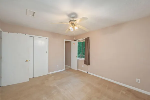 a view of an empty room with a ceiling fan