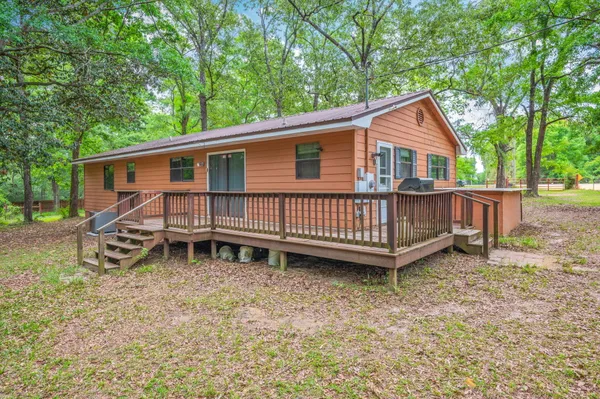 a view of a house with a yard and deck
