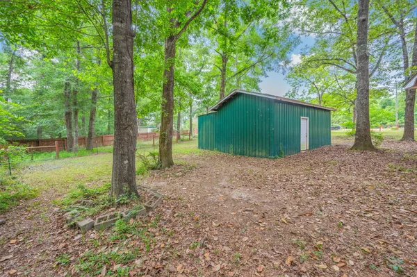 a view of a house with backyard and trees