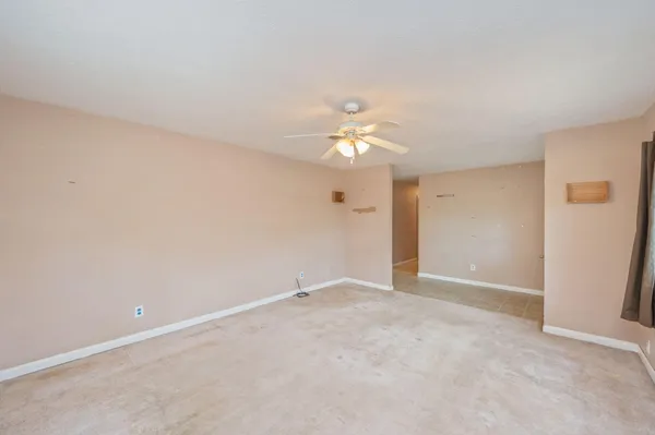 a view of an empty room with a chandelier fan