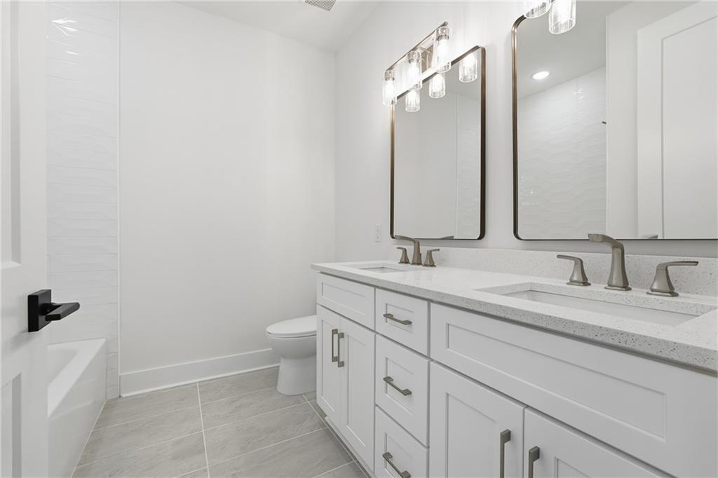 531 South Main Street, Unit 320 Alpharetta, GA 30009 - Photo 26 of 43 a bathroom with a double vanity sink and mirror with toilet