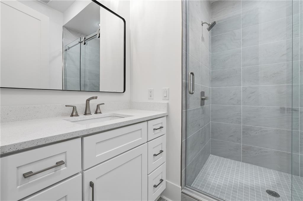 531 South Main Street, Unit 320 Alpharetta, GA 30009 - Photo 30 of 43 a bathroom with a granite countertop sink a mirror and shower