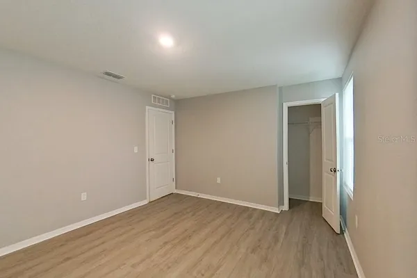 a view of an empty room with wooden floor