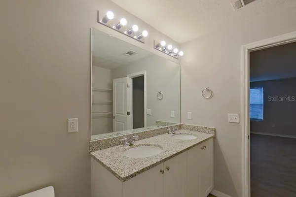 a bathroom with a granite countertop sink and a mirror