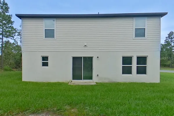 a view of wooden house with a backyard