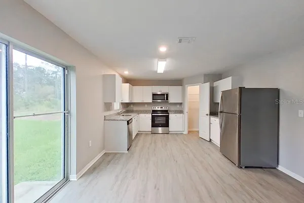 a kitchen with a refrigerator a sink and cabinets