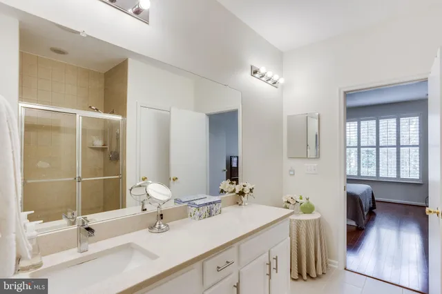 a bathroom with a double vanity sink a mirror and a bathtub