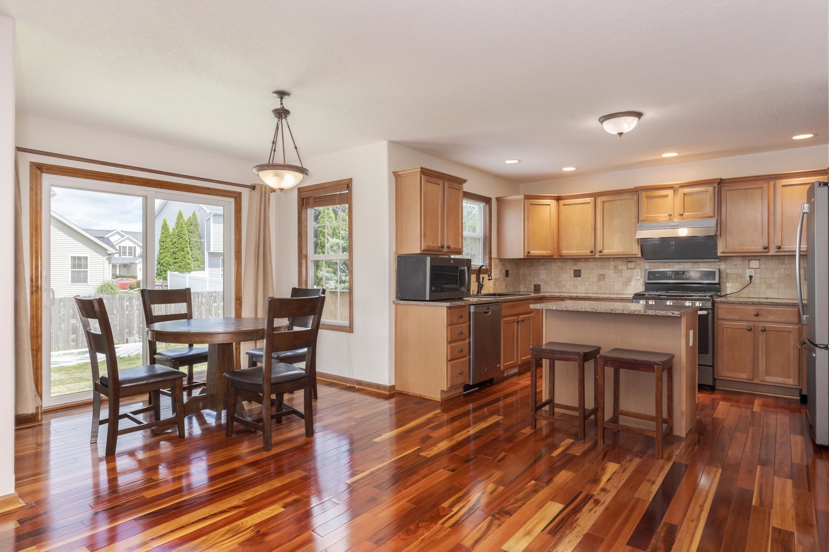 3250 Topaz Road Normal, IL 61761 - Photo 17 of 54 a kitchen with a table chairs refrigerator and cabinets