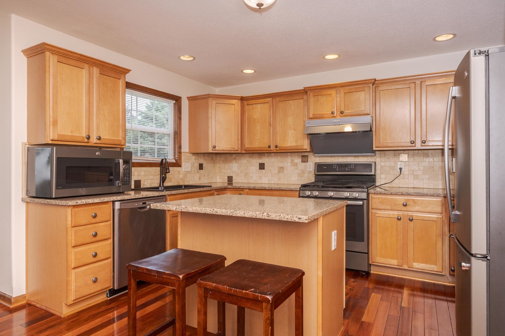 3250 Topaz Road Normal, IL 61761 - Photo 20 of 54 a kitchen with stainless steel appliances granite countertop a stove a sink dishwasher a refrigerator and a microwave oven with wooden floor