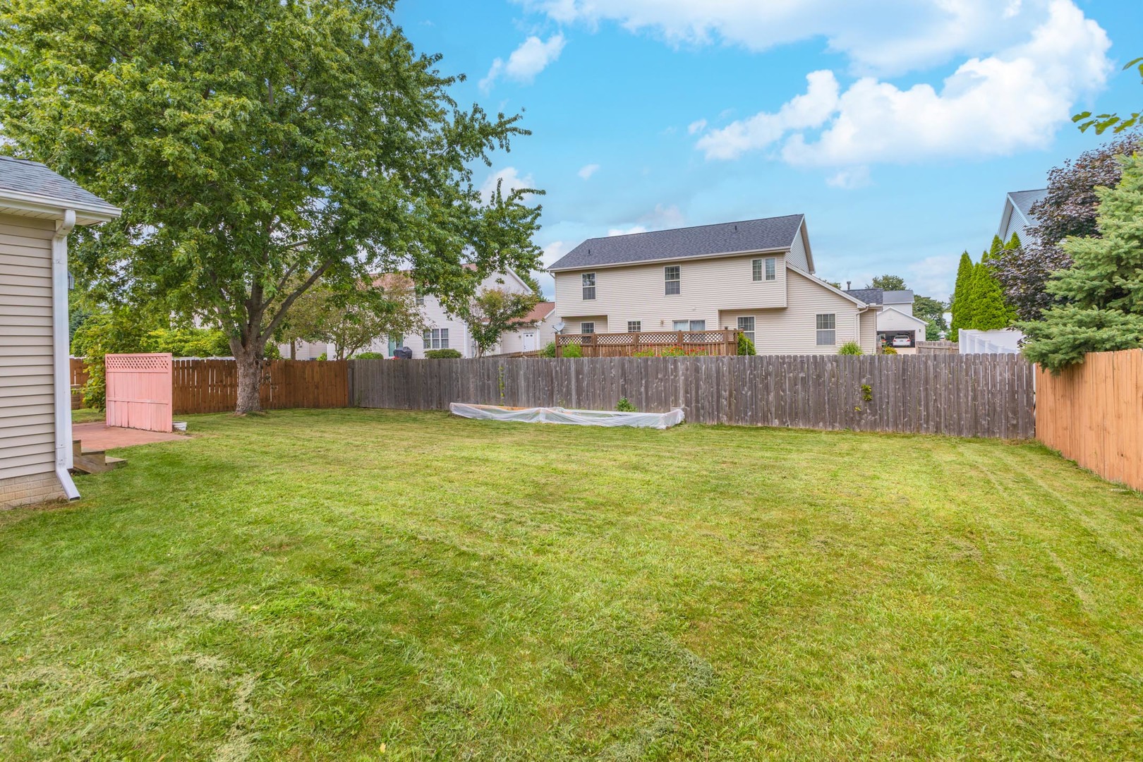 3250 Topaz Road Normal, IL 61761 - Photo 49 of 54 a view of a backyard with a large tree and wooden fence