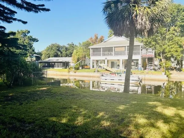 a front view of a house with a garden and lake view