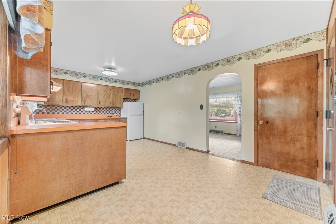 900 Ryan Road Medina, OH 44256 - Photo 10 of 40 Kitchen with sink, backsplash, light tile patterned floors, ventilation hood, and white fridge