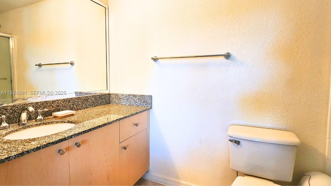 2557 Centergate Drive, Unit 101 Miramar, FL 33025 - Photo 12 of 14 a bathroom with a granite countertop sink and a toilet